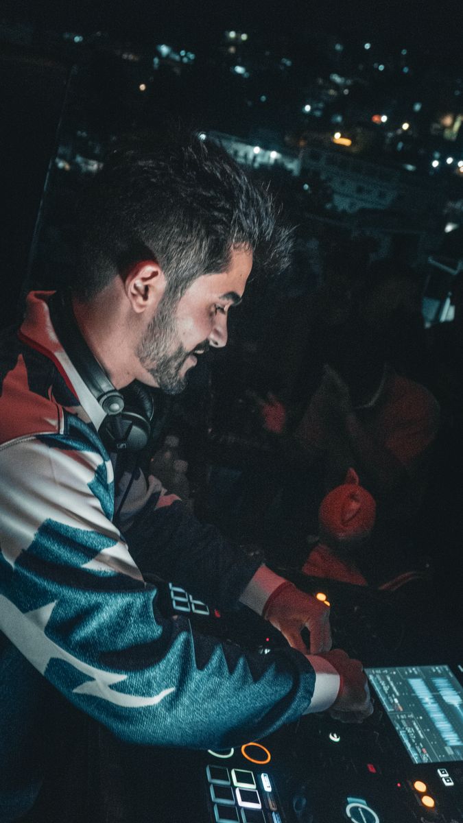 DJ tocando com a cidade ao fundo