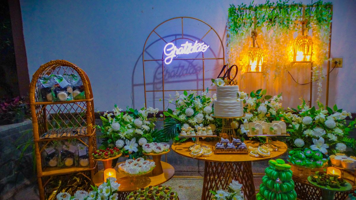 Mesa do bolo com decoração e letreiro em neon
